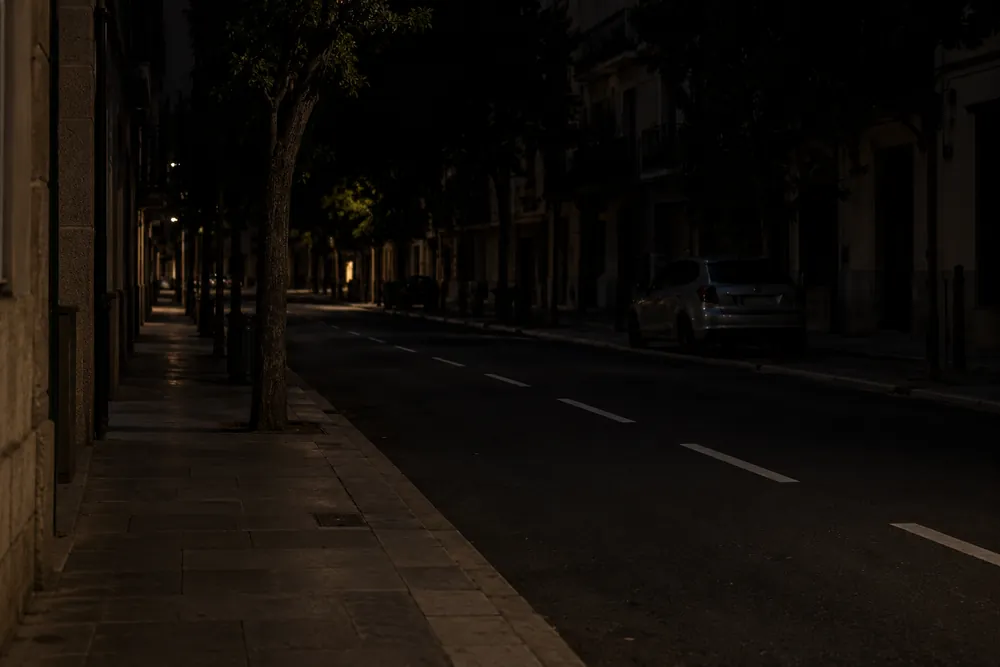 Calle urbana sin alumbrado público suficiente de noche.
