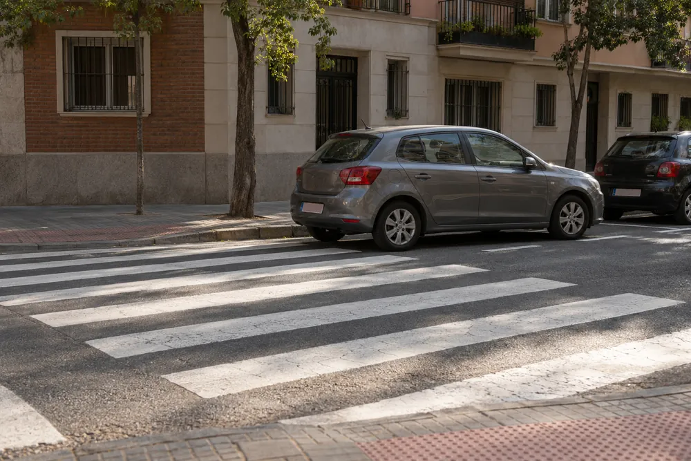 Turismo estacionado ocupando parte de un paso de cebra.