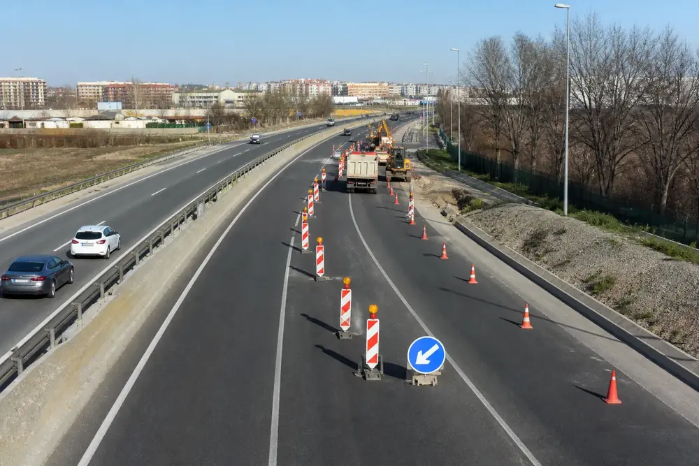 Obras en autovía con conos, camión de señalización y desvío de carril