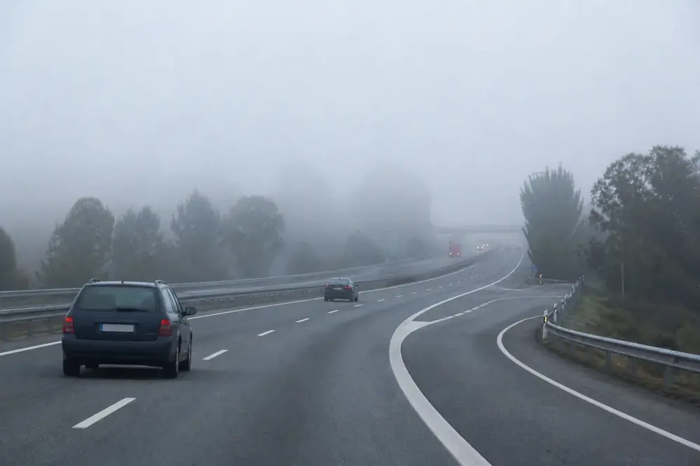 Autovía con niebla densa y vehículos apenas visibles