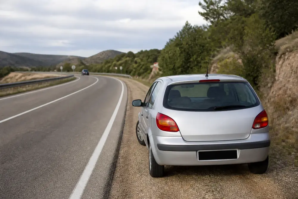 Vehículo detenido en el arcén de una carretera convencional