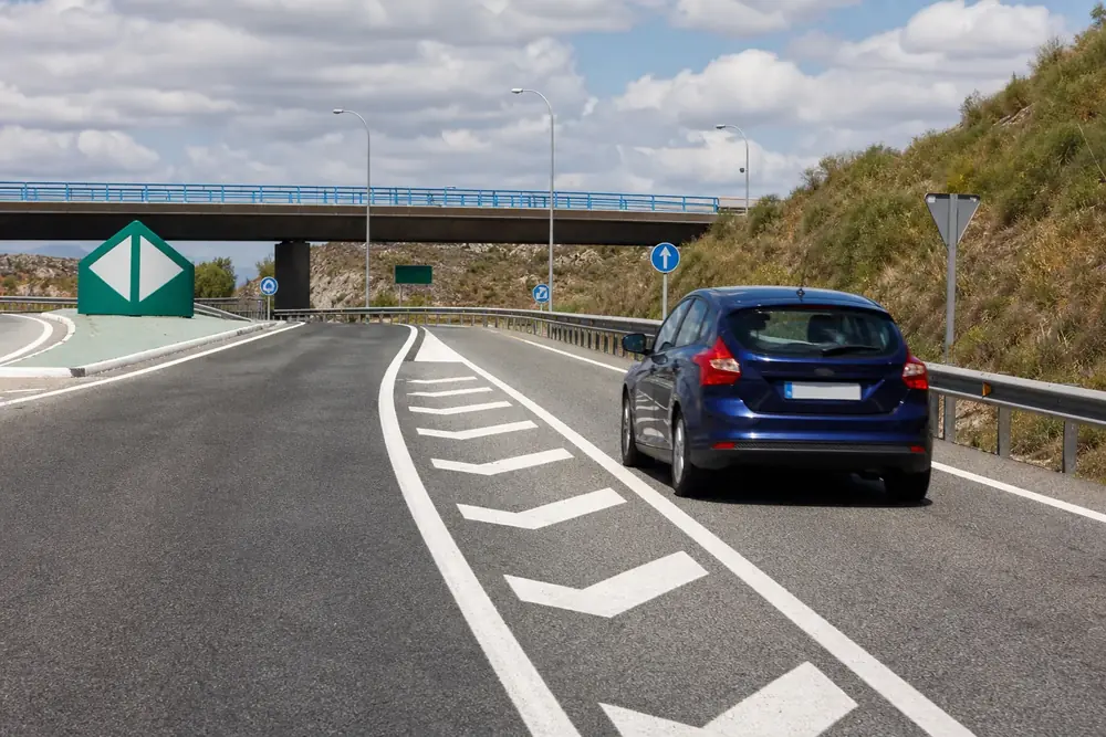 Vehículo en un ramal de enlace junto a marcas de canalización