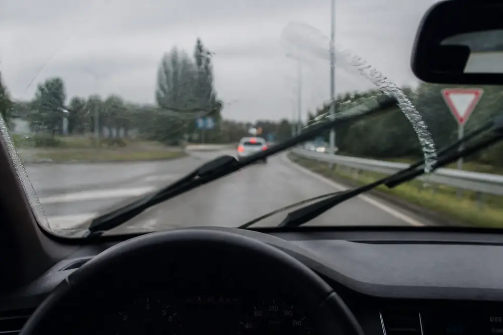 Vista de la carretera a través de un parabrisas con lluvia